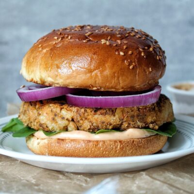 Cannellini bean burger with sirarcha mayo sauce, spinach, and sliced onions.