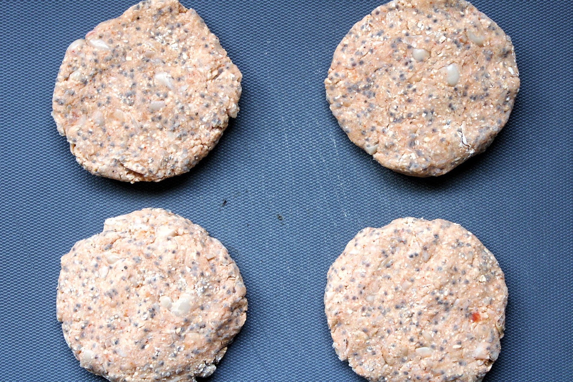 Four, uncooked vegan burger patties.