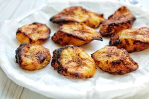 Baked sweet plantains on a plate lined with parchment paper