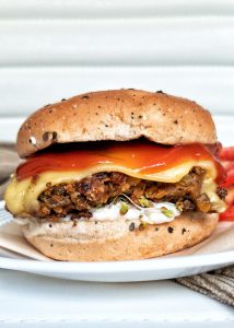 Plant-based lentil burger sprouts, vegan mayo, vegan cheese, tomatoes, and tomato sauce, on a burger bun