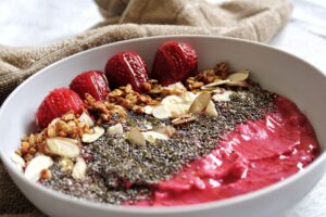 Raspberry strawberry banana smoothie with chia seeds, almonds, and granola