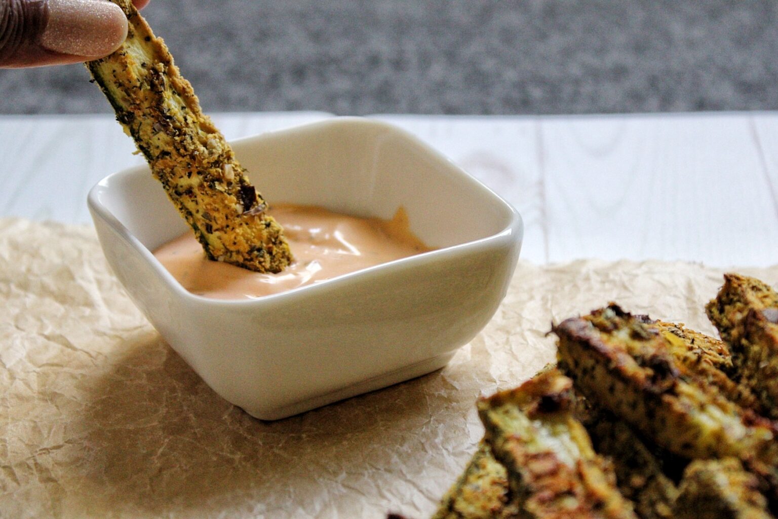 Zucchini fry dipped into sauce.