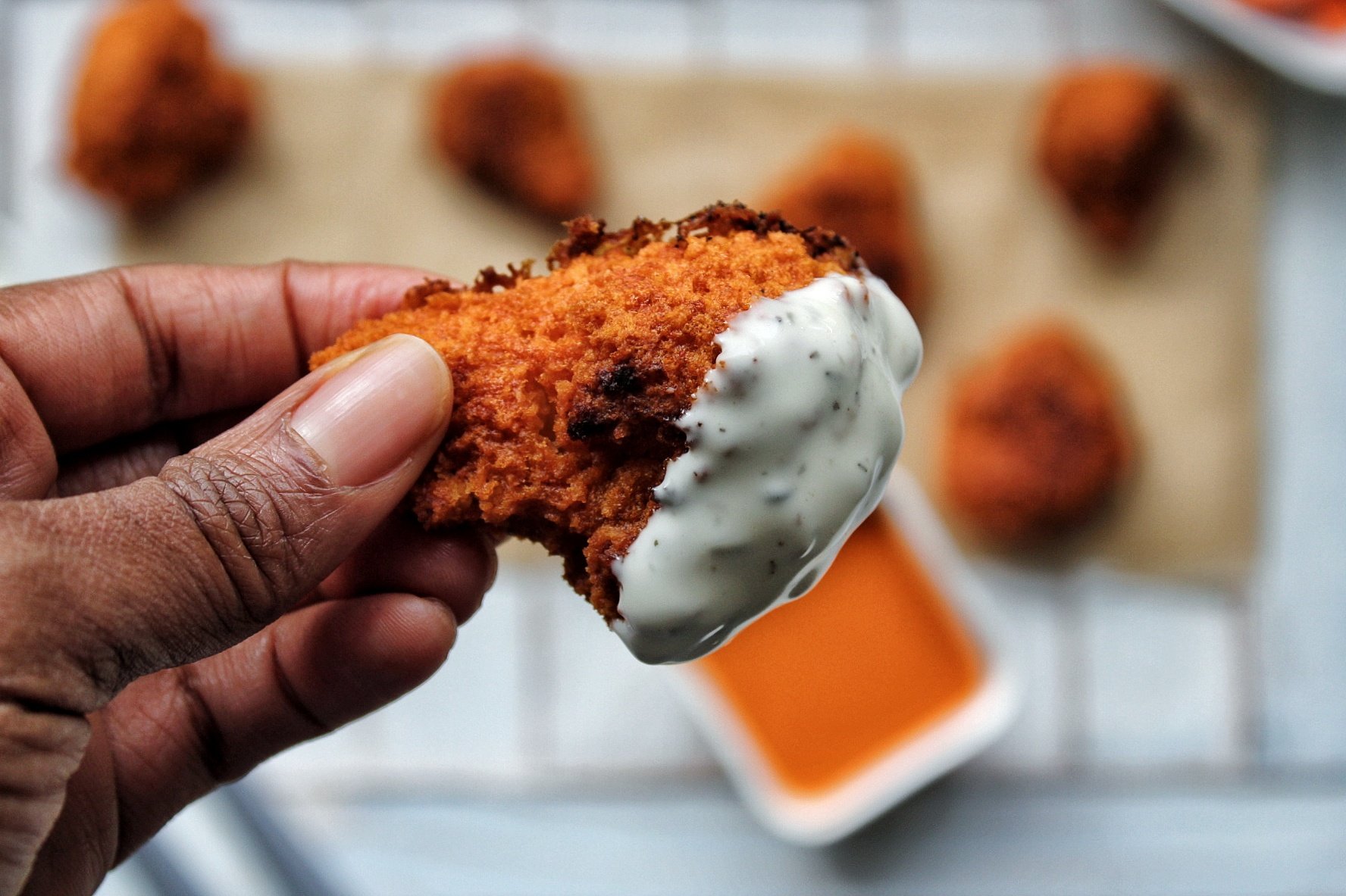 Buffalo cauliflower wing dipped in ranch dressing