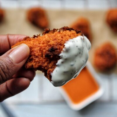 Cauliflower buffalo wing dipped in vegan ranch dressing