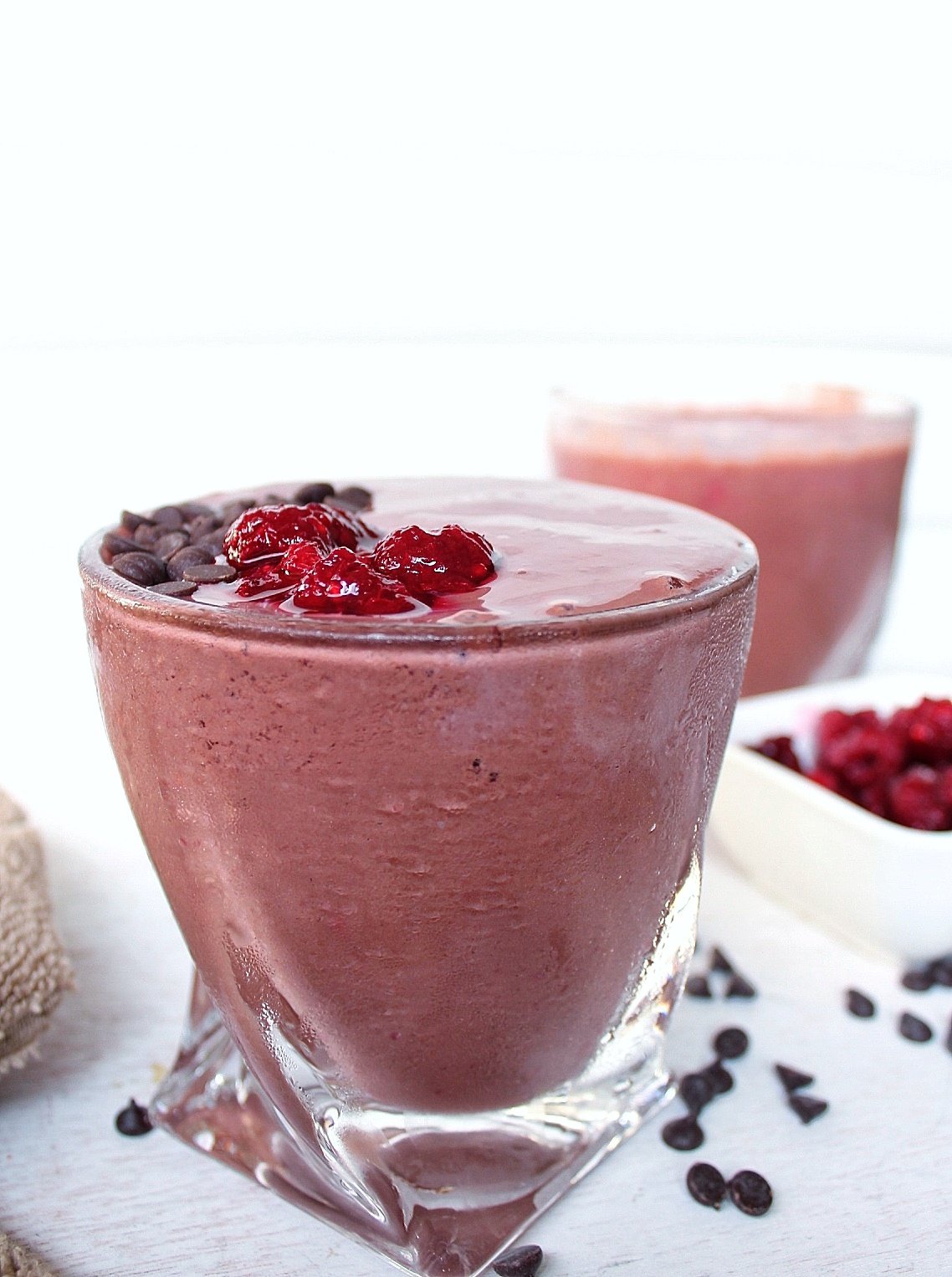 Raspberry chocolate smoothie topped with chocolate chips and raspberries