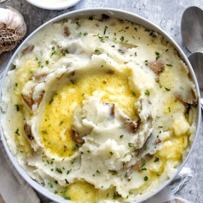 Fluffy mashed potatoes topped with garlic butter, garlic salt, butter, and parsley.