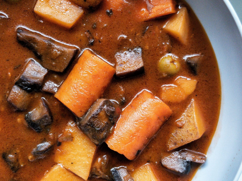 Puerto Rican vegan beef stew or "carne guisda" in a grey bowl with a side of white rice.