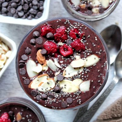 Chocolate chia seed pudding with slices almonds, chocolate chips, and raspberries