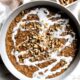 Sweetened, cooked red split lentils with a drizzle of coconut milk and crushed walnuts in a bowl.