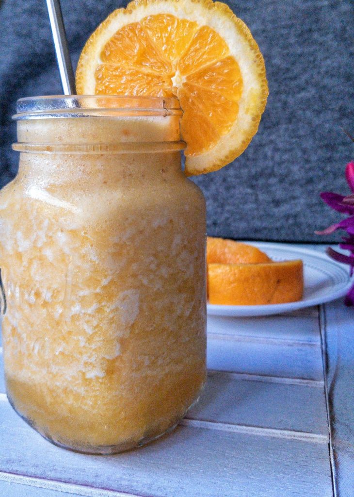 Cold pineapple smoothie with a slice of orange
