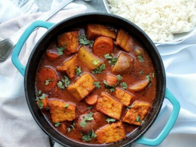 Cooked tofu guisado or tofu stew made with tofu, carrots, potatoes, and olives. Topped with chopped cilantro.