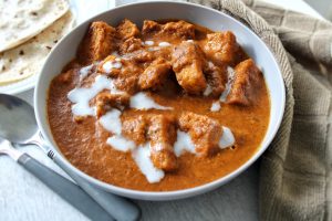 Meatless butter chicken in a gray bowl and side of roti