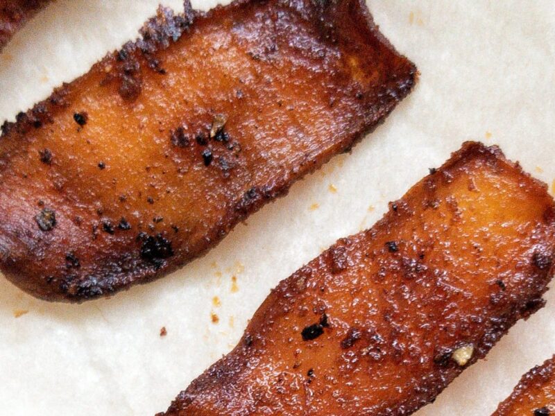 Strips of veggie bacon against parchment paper