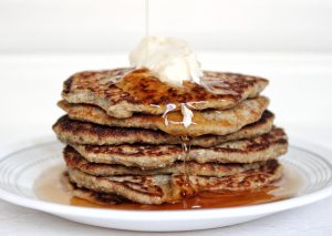 Stack of gluten-free banana vegan pancakes with vegan butter and syrup