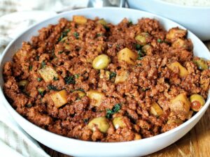 Vegan picadillo with Spanish green olives and potatoes in a serving bowl.