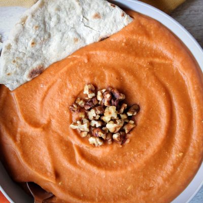 Soup made with lentils, carrots, and ginger served with a homemade flatbread