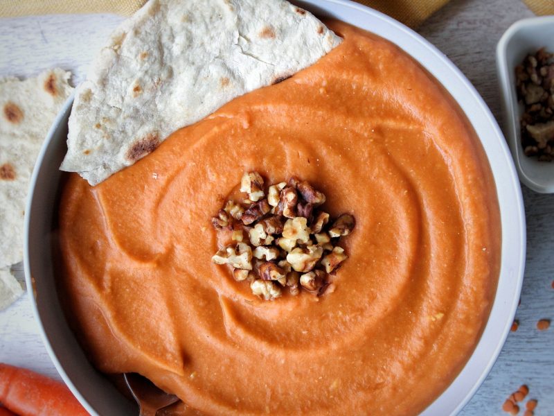 Soup made with lentils, carrots, and ginger served with a homemade flatbread