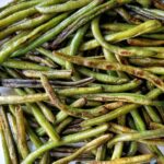 Blistered green beans on a plate.