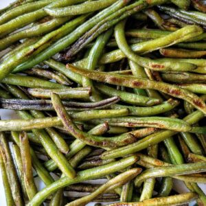 Blistered green beans on a plate.