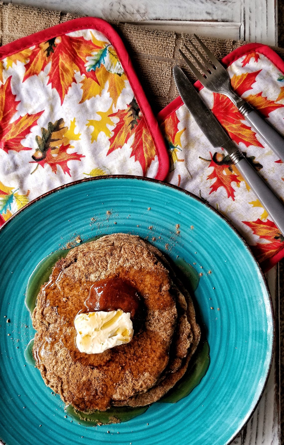 Spiced gluten-free pancakes topped wit hpantry syrup and vegan butter.