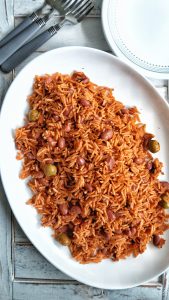 Seasoned Puerto Rican yellow rice with red beans, Spanish olives, tomato sauce on a large plate