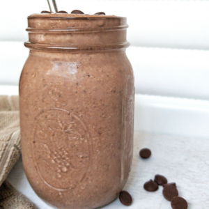 Protein chocolate peanut butter smoothie in a mason jar with a metal straw