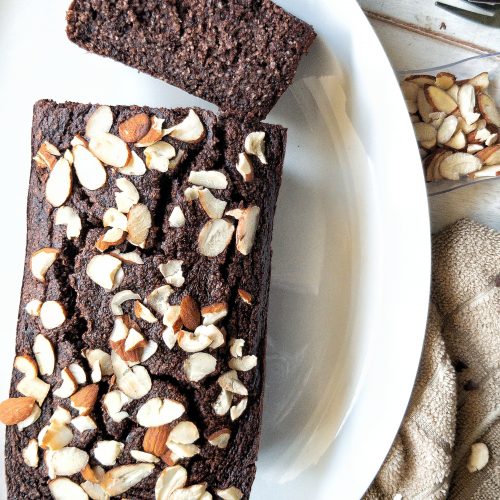 A loaf of gluten-free double chocolate banana bread topped with sliced almonds