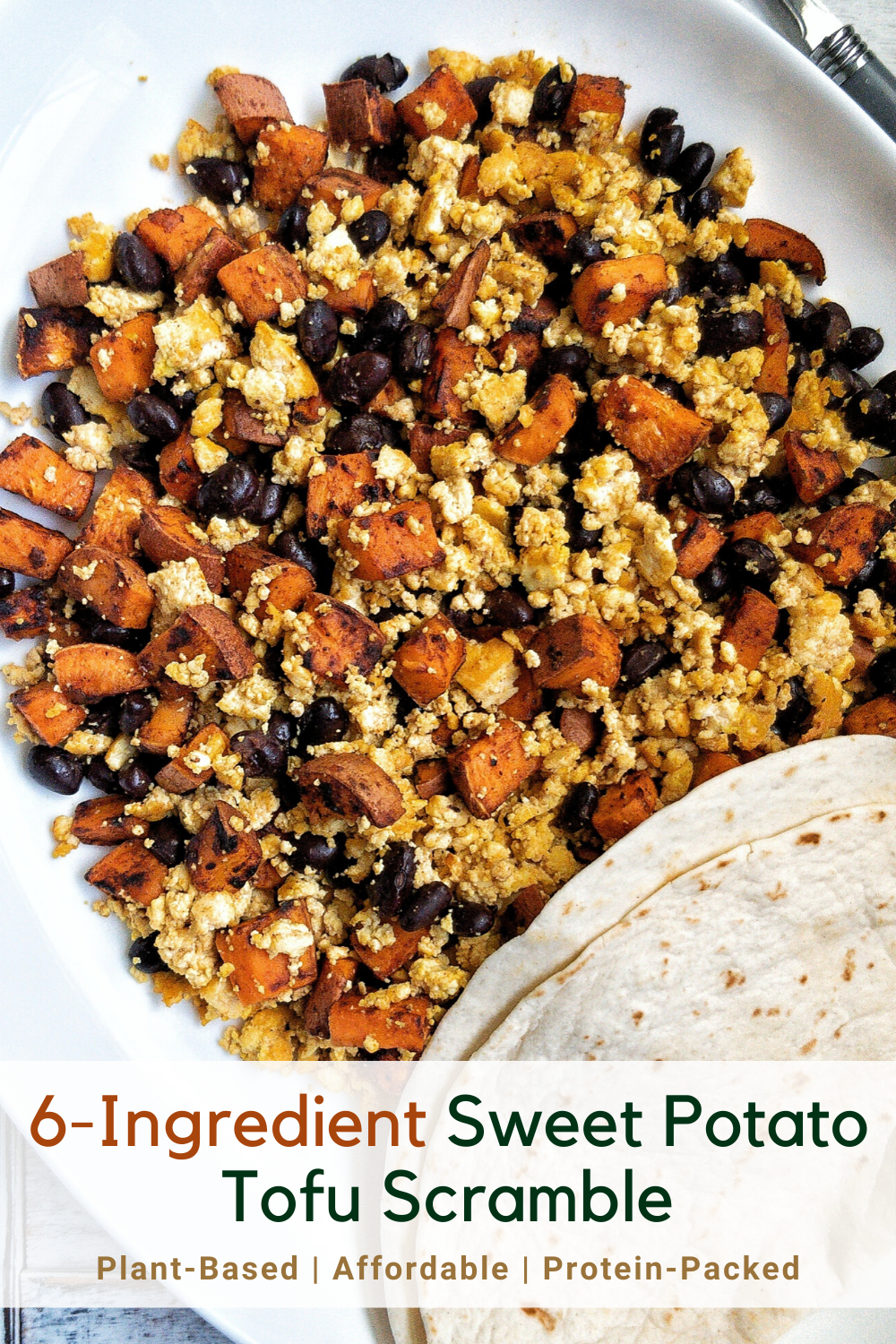 A platter with tofu scramble loaded with sweet potato, black beans, and a side of tortillas 