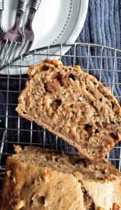 Oven-baked healthy banana nut bread with walnuts. With one slice cut from the loaf.
