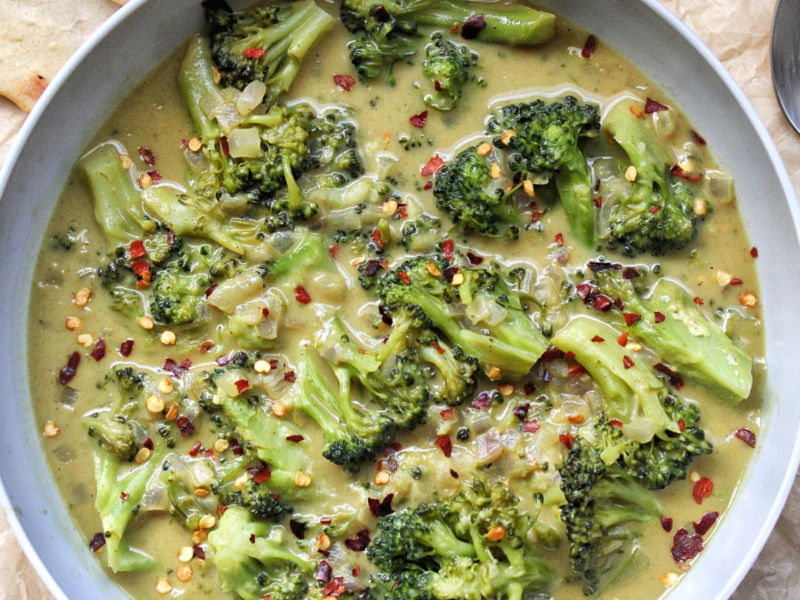 Bowl of vegetable broccoli curry with flatbread.
