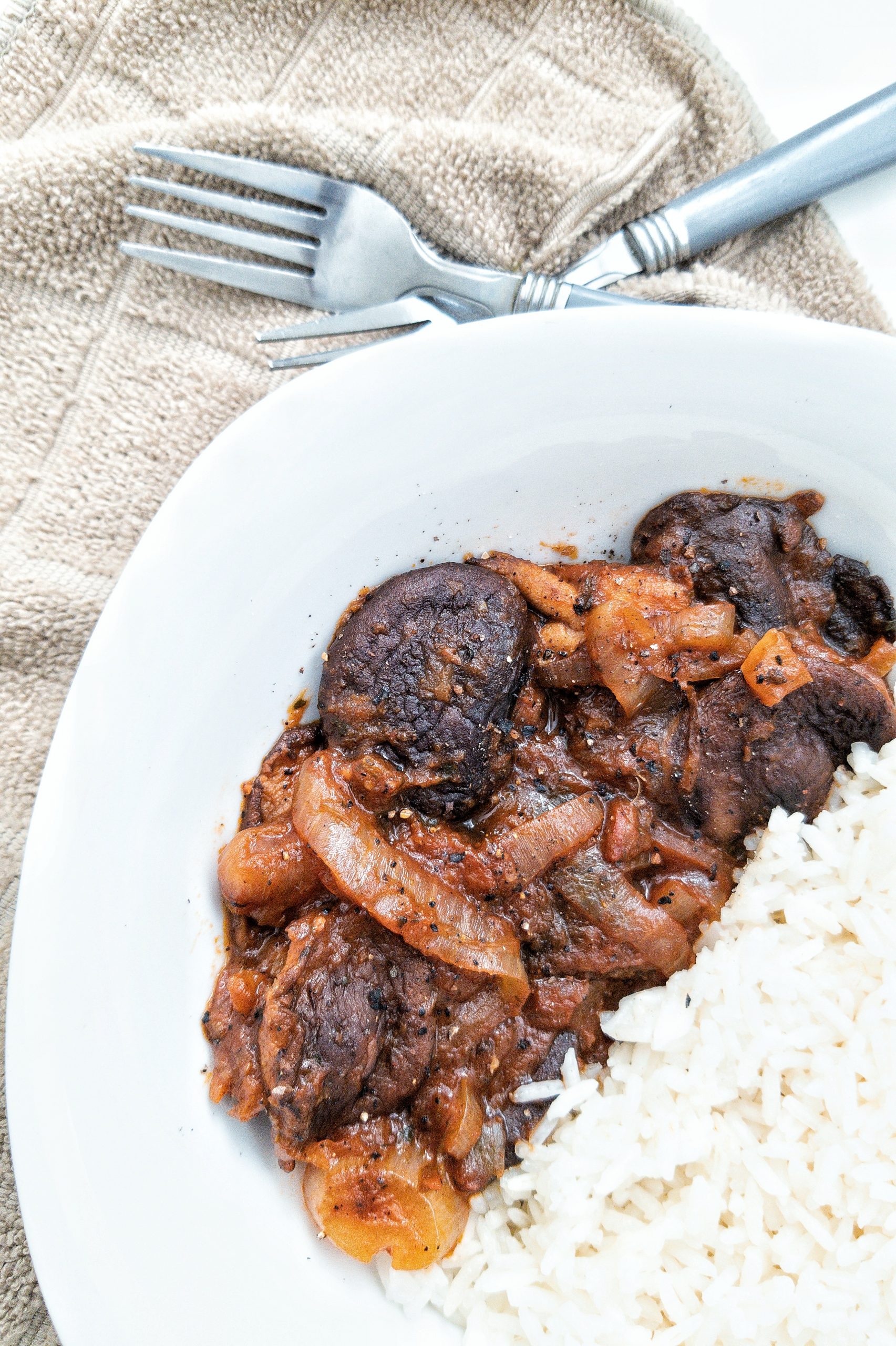 Stewed mushroom with onion and a side of rice in a bowl