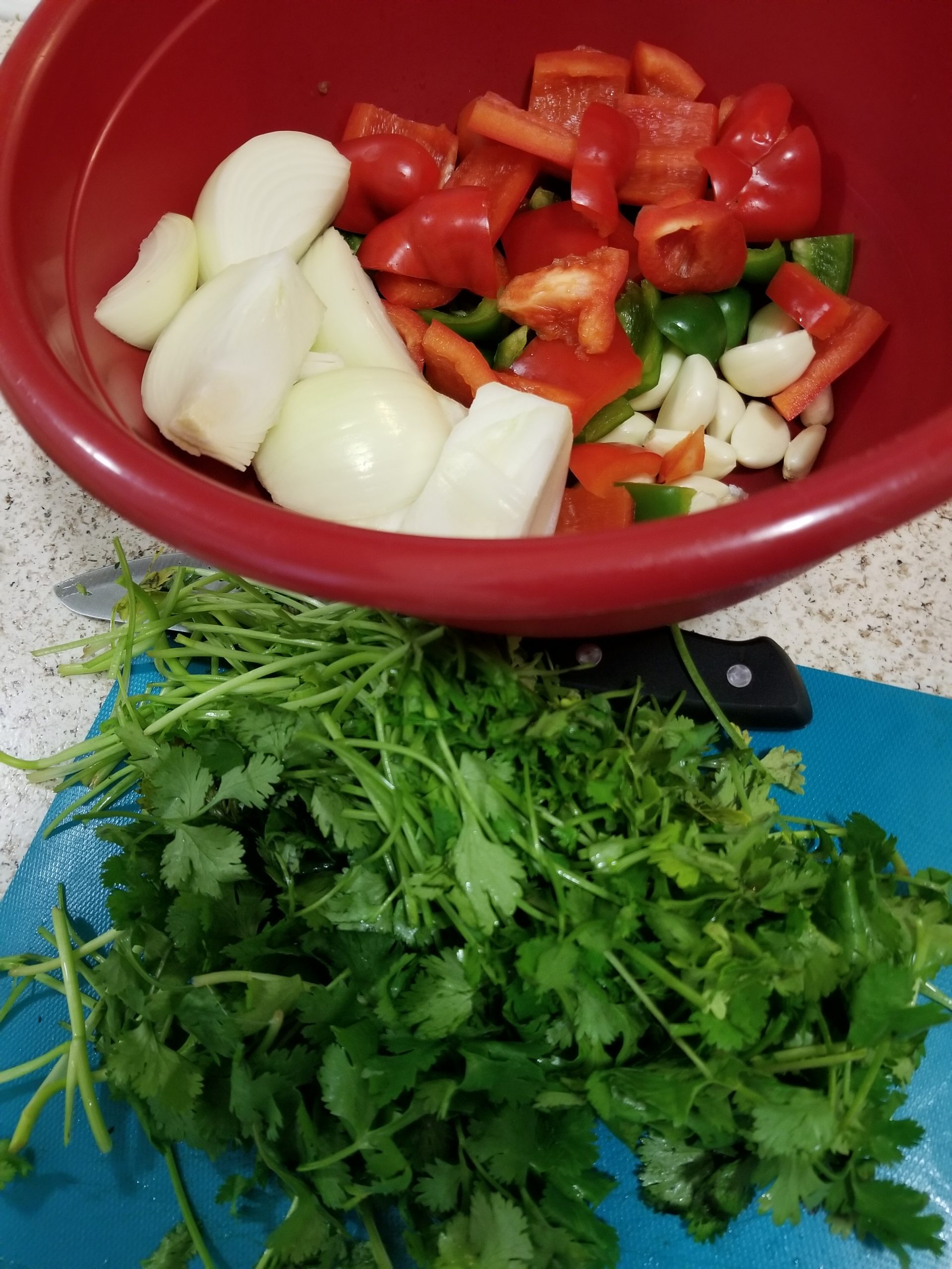 Chopped cilantro, onion, red bell pepper, green bell pepper, and garlic in a large bowl. 