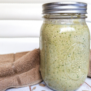 Green, creamy cilantro sauce in a clear glass canning jar.