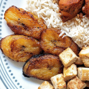 A plate with sweet fried plantains, rice, and tofu.