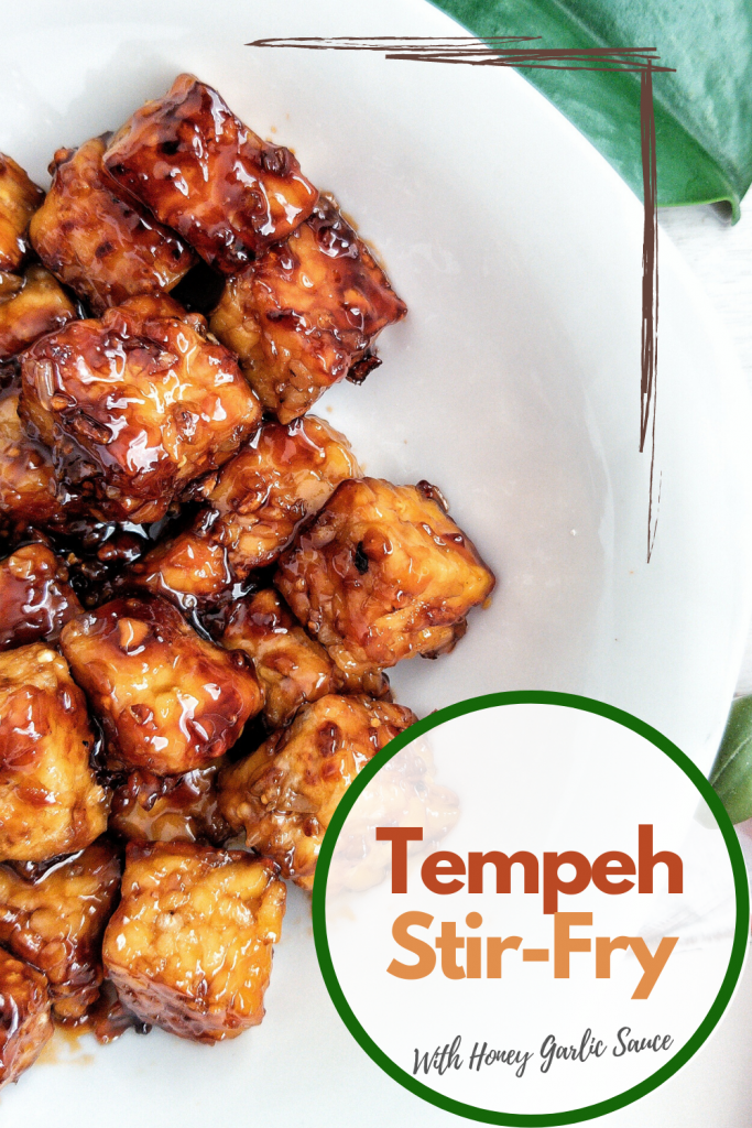 Pinnable image for Pinterest. Stir fry tempeh with a honey garlic sauce in a white bowl