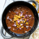 Black bean soup in a bowl topped with corn and chopped red onon