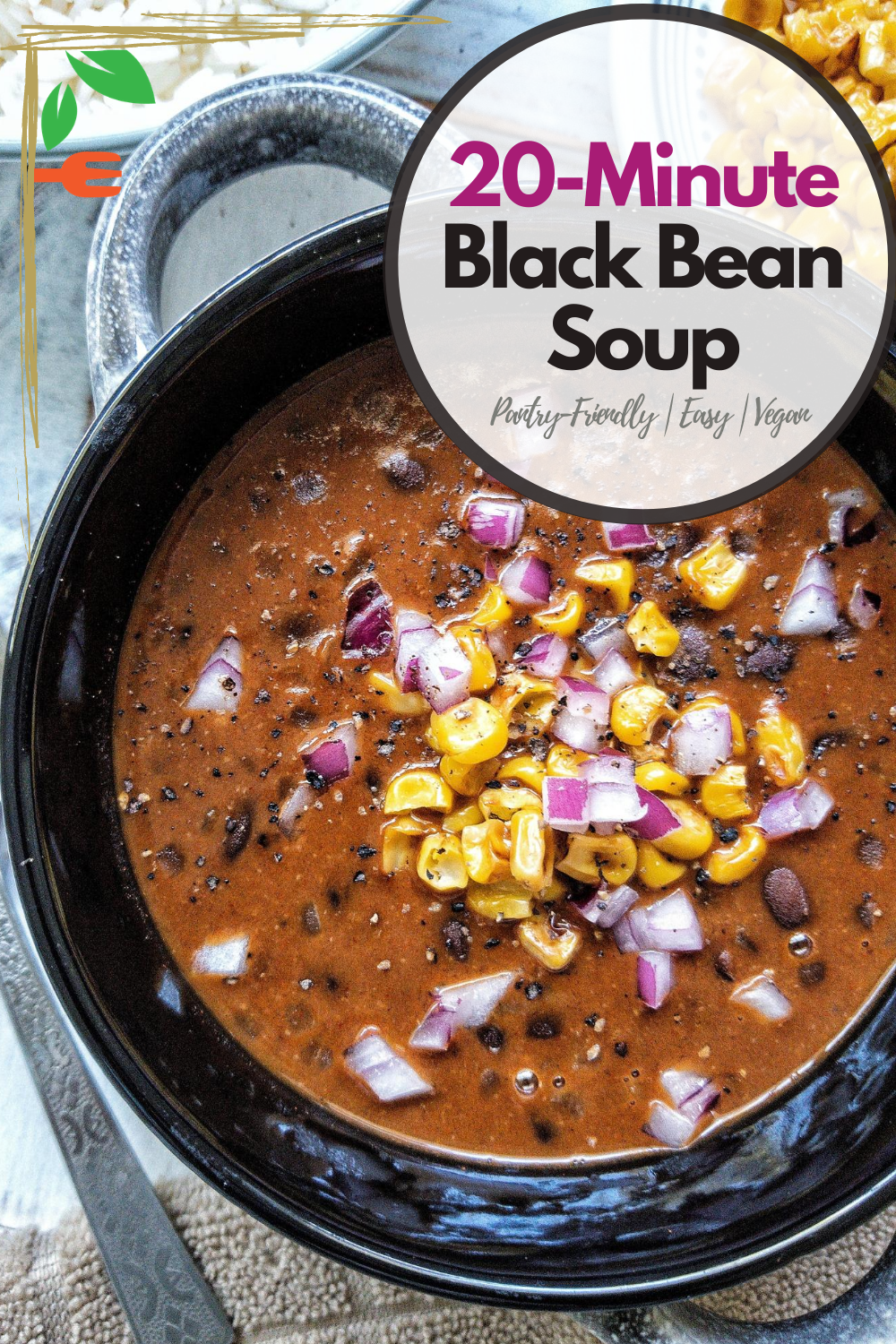 Bowl of black bean soup topped with red chopped onions and pan-roasted corn