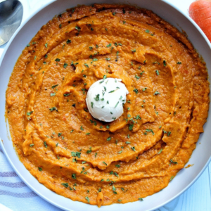 Mashed carrots topped with a scoop of butter and parsley