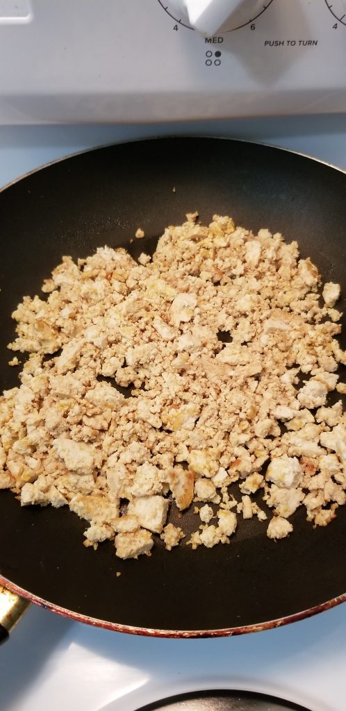 Close up of pan-fried, crumble tofu with soy suace and nutritional yeast.