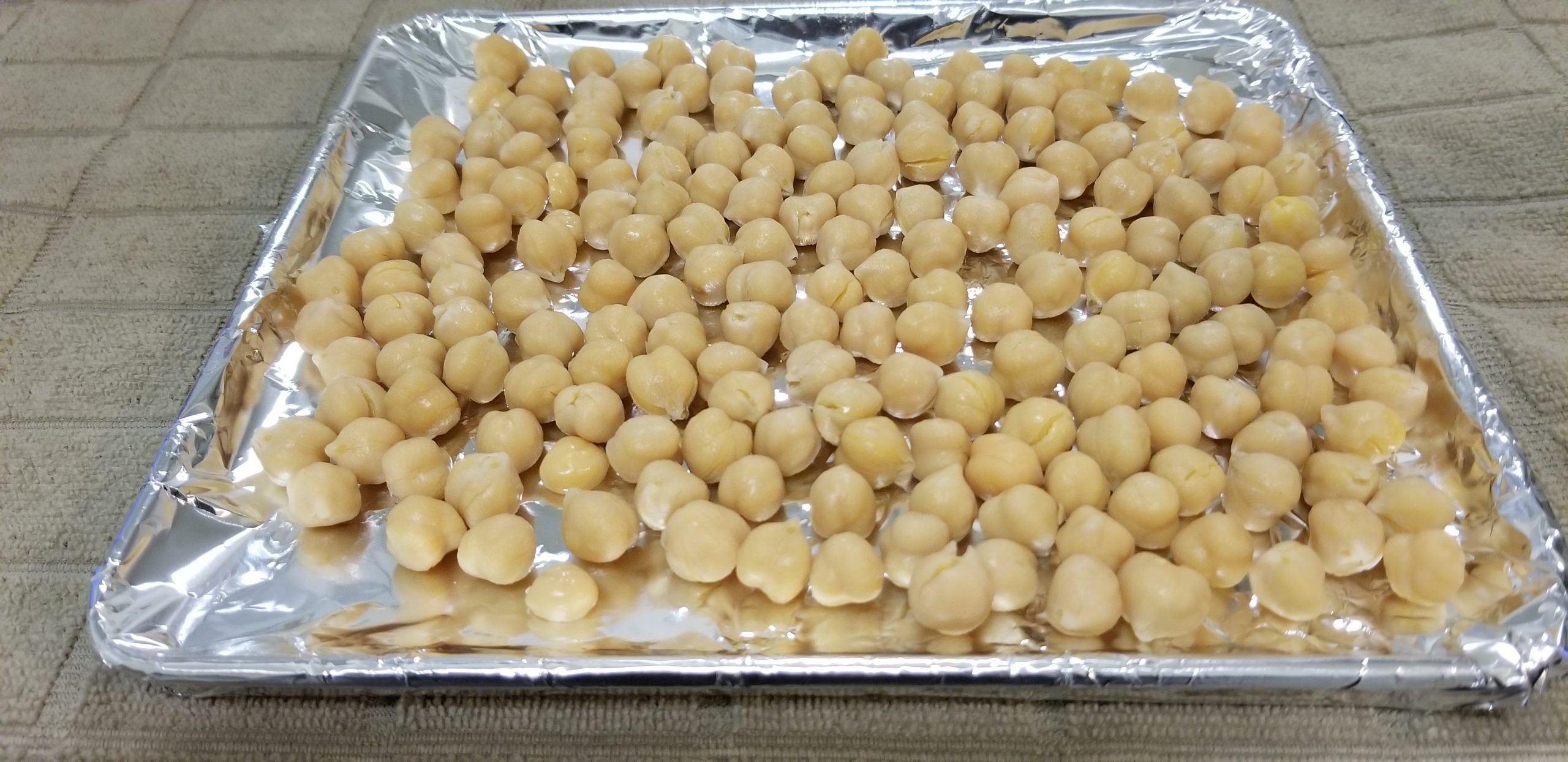 Chickpeas in a toaster oven tray lined with aluminum foil