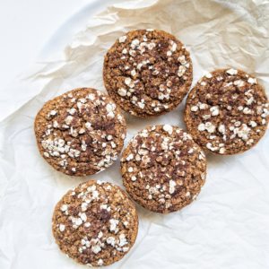 Five fluffy chia seed pumpkin muffins on parchment paper