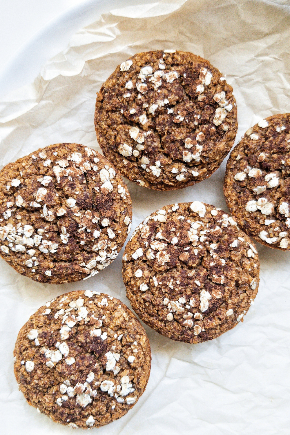 Five chia seed pumpkin muffins on  brown parchment paper