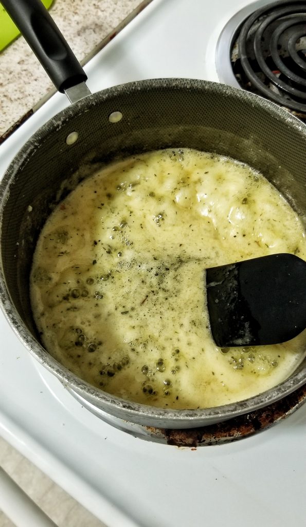 Melted vegan butter with crushed garlic and Italian seasoning in a sapucepan