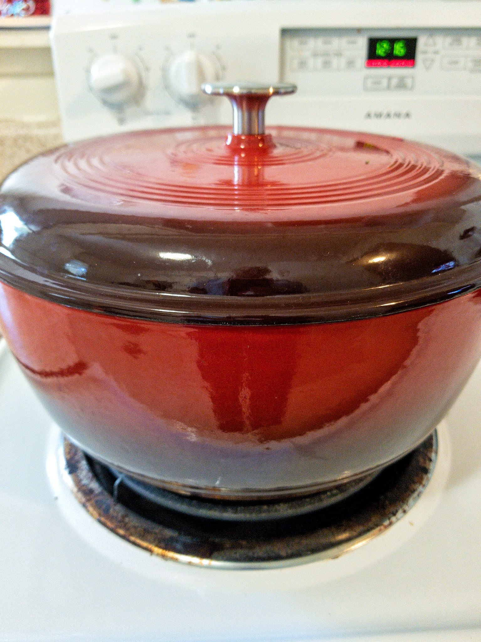 Red dutch oven on a stovetop burner