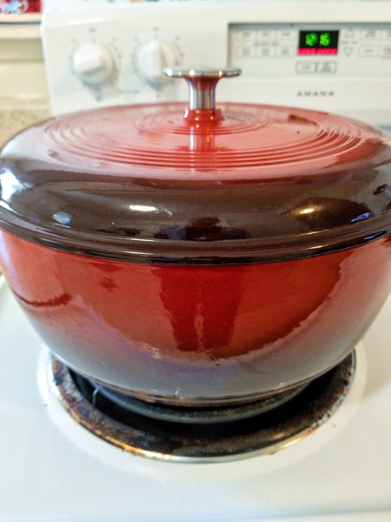 Red dutch oven on a stovetop