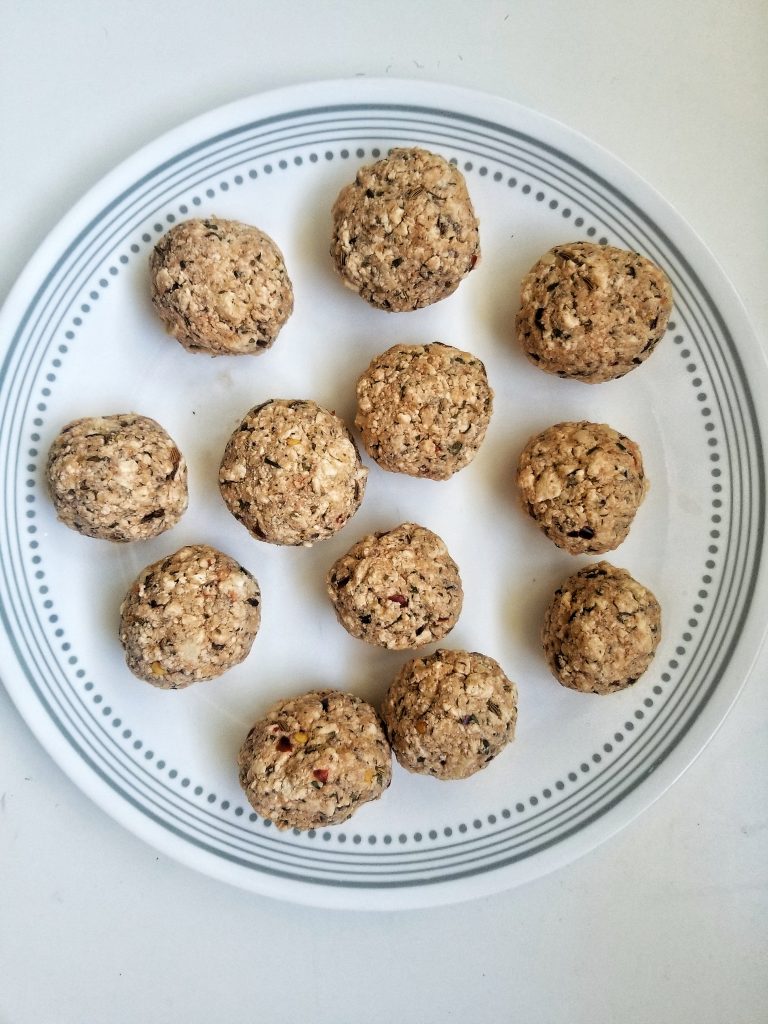 Uncooked, vegan tofu meatballs on a white plate