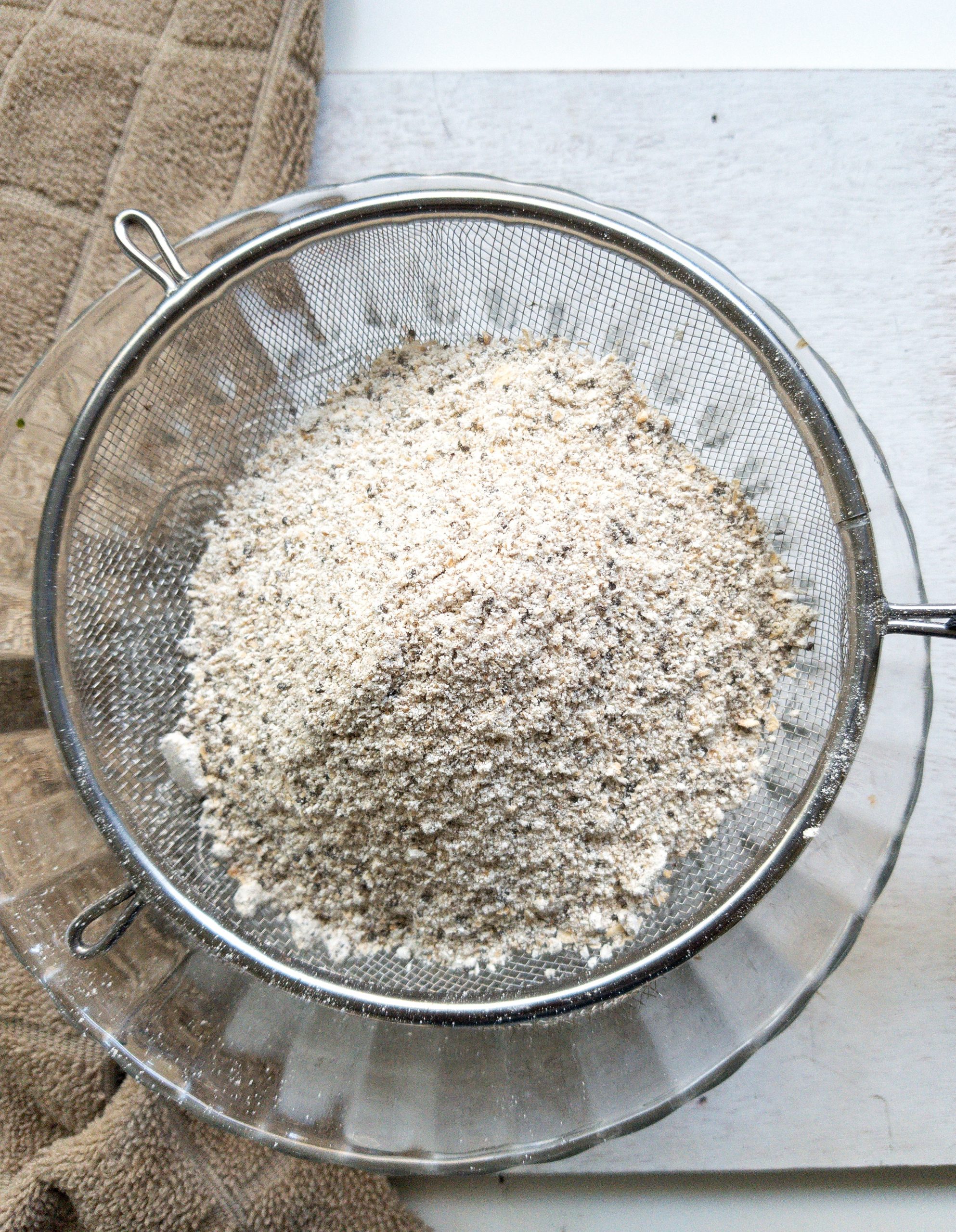 Oat flour sifting over a mixing bowl