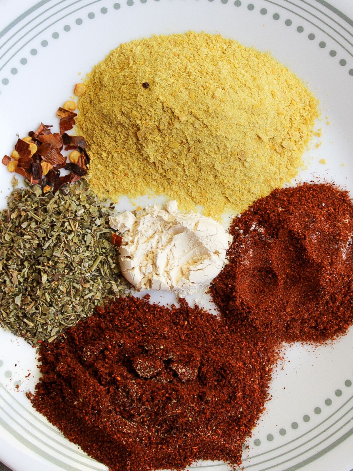 A collection of spices on a small white plate.