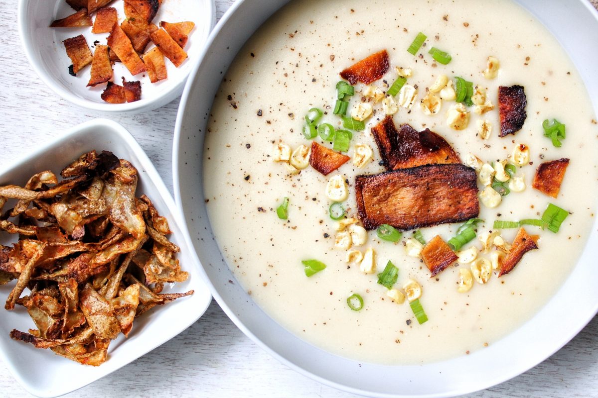 Plant-based creamy, garlic potato soup topped with vegan bacon, green onions, and corn. With a side of roasted potato peels.