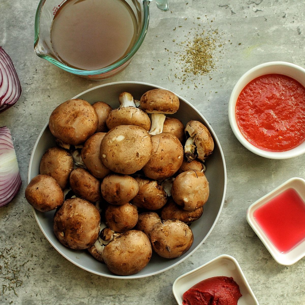 Mushrooms in a bowl, crushed tomatoes, tomato paste, red wine vinegar, mushroom broth, red onions.